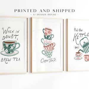 May include: Three framed art prints with tea-related designs. One says "When in doubt, brew tea," another asks "Cuppa tea?" and the third says "Put the kettle on!" Each print features colourful teacups and teapots, perfect for a kitchen.