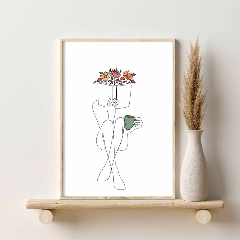 May include: Line art print of a person sitting with a book and a cup of coffee. The book is open and has flowers on top of it. The print is in black and white with a few pops of color in the flowers.