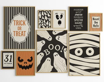May include: A collection of framed Halloween-themed art prints. The prints feature various spooky designs, including ghosts, a mummy, a jack-o'-lantern, and text that reads "Trick or Treat", "Haunt the Halls", and "Boo!". The color palette is primarily black, white, and orange.