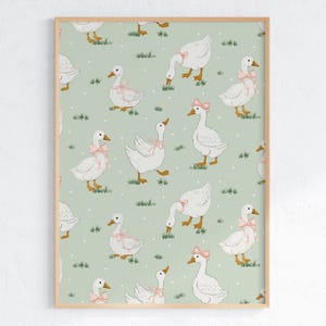 May include: A framed print featuring a repeating pattern of white geese with pink bows on a light green background. The geese are depicted in various poses, with some grazing on grass and others standing. The artwork has a whimsical, vintage aesthetic.