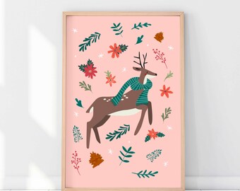 May include: A framed art print featuring a brown deer wearing a teal scarf, surrounded by floral and leaf illustrations on a pink background. The artwork has a light wood frame and is suitable for seasonal or holiday decor.