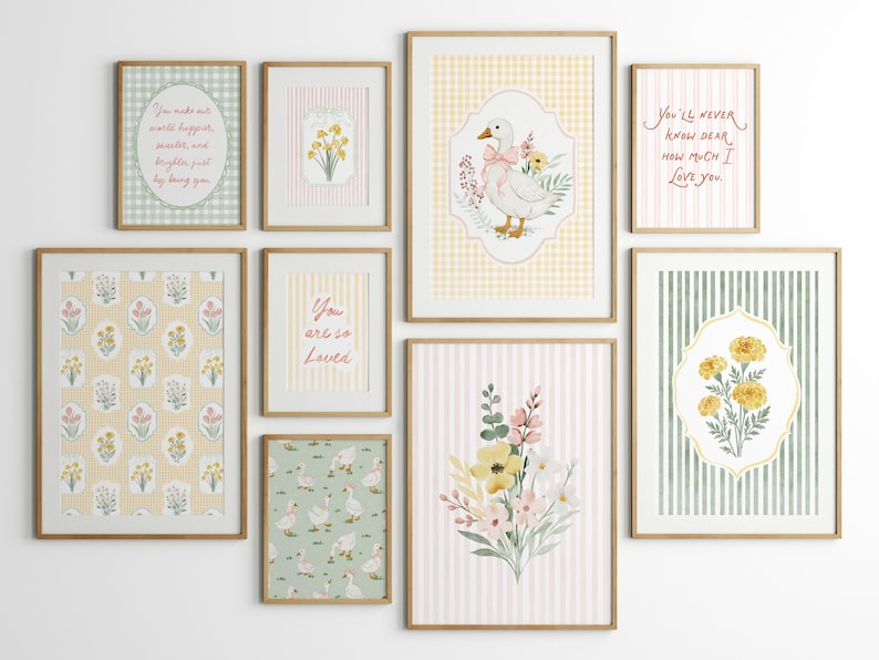 May include: A collection of framed art prints with a soft, pastel color palette. The prints feature floral patterns, a goose illustration, and inspirational quotes. The frames are a light wood color, and the overall aesthetic is charming and whimsical.
