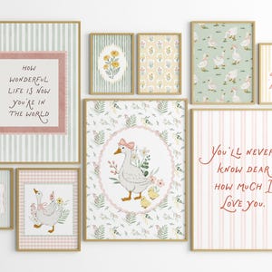 May include: A collection of framed art prints with a whimsical, pastoral theme. The prints feature illustrations of geese, floral patterns, and inspirational quotes in a soft color palette of pink, green, and yellow. The frames have a gold finish.