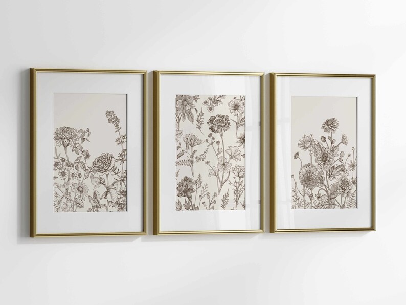 May include: Three framed botanical art prints. Each print features detailed sepia-toned illustrations of various flowers and foliage. The frames are gold-colored, adding a touch of elegance to the floral artwork. The prints are displayed against a white background.