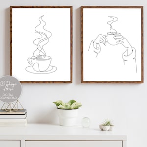 May include: Two black and white line art prints of coffee cups. The first print shows a coffee cup with steam rising from it. The second print shows a hand holding a coffee cup.