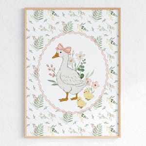 May include: A framed watercolor print featuring a white goose with a pink bow, surrounded by flowers and two yellow chicks. The artwork is set against a floral patterned background, creating a charming, pastoral scene.
