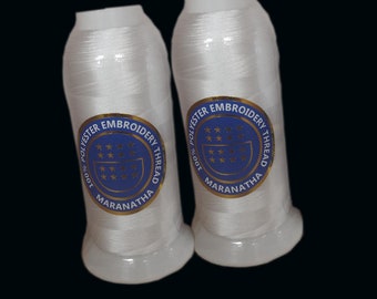 May include: Two spools of white 100% polyester embroidery thread with blue and gold labels that read "100% Polyester Embroidery Thread Maranatha".