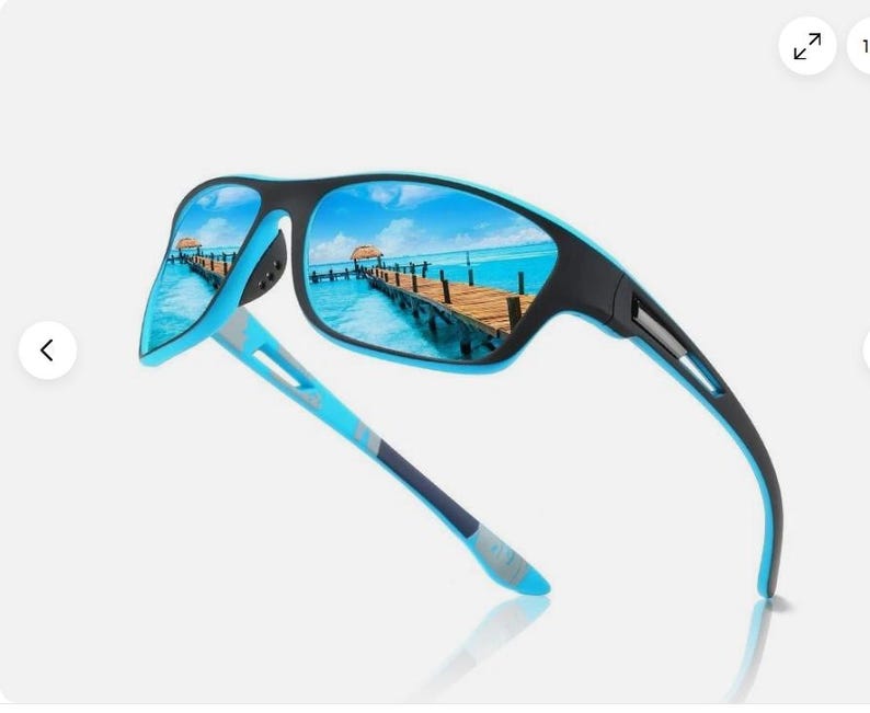 May include: Sport sunglasses with a black frame and blue accents. The lenses reflect a scenic view of a pier over turquoise water. The temples are blue and gray, offering a stylish and functional design.