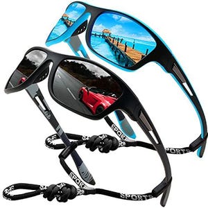 May include: Two pairs of sports sunglasses. One pair has a black frame with blue accents and mirrored lenses reflecting a beach scene. The other pair has a black frame with mirrored lenses reflecting a red car on a road. Both have black cords.