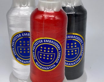May include: Three spools of 100% polyester embroidery thread. The spools are white, red, and black. Each spool has a blue label with the text "100% Polyester Embroidery Thread" and the word "Maranatha" in a circle.