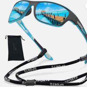 May include: Sport sunglasses with a black and blue frame and mirrored lenses reflecting a beach scene. The sunglasses have a black strap with the word "SPORTS" printed on it. A black carrying case is also included.