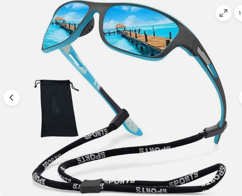 May include: Sport sunglasses with a black and blue frame and mirrored lenses reflecting a beach scene. The sunglasses have a black strap with the word "SPORTS" printed on it. A black carrying case is also included.