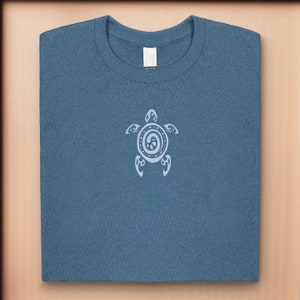 May include: A blue t-shirt with a white stylized turtle design on the front.
