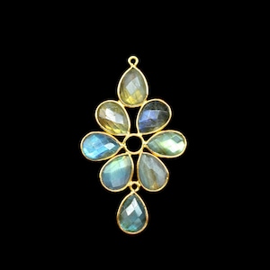 Peut inclure: Un pendentif doré composé de neuf pierres précieuses de labradorite facettées en forme de poire, disposées en un motif floral symétrique. Les pierres présentent des reflets irisés bleus, verts et jaunes, serties dans un cadre en métal doré.
