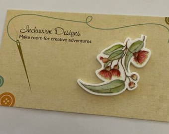 May include: A card with the text "Inchworm Designs" and "Make room for creative adventures". The card features a white cutout of a watercolour painting of a eucalyptus branch with red flowers.