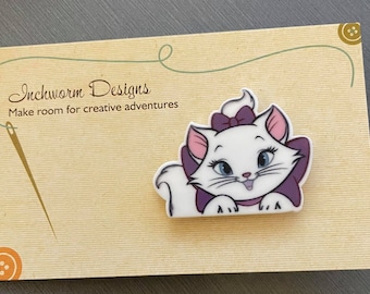 May include: A white cat with purple bow and collar, with the text "Inchworm Designs. Make room for creative adventures."
