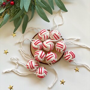 May include: A set of ten red and white striped Christmas ornaments made of knotted rope with white twine hangers.