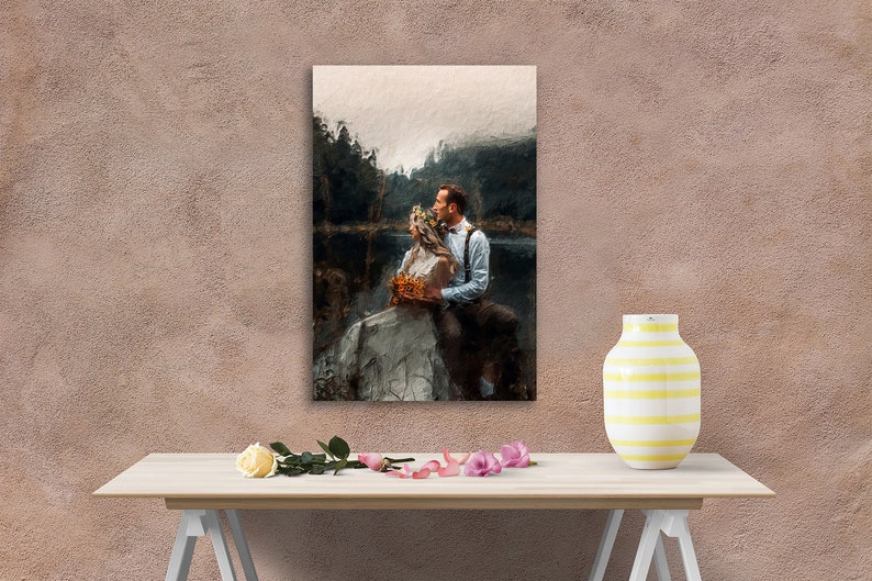 Op de afbeelding: Een schilderij van een stel in een bosrijke omgeving. De vrouw draagt een witte jurk en een bloemenkrans. De man draagt een donker pak en een stropdas. Ze staan ​​bij een meer en kijken elkaar aan.