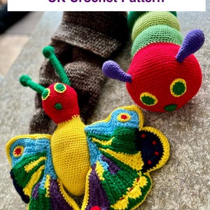 May include: A crocheted butterfly and caterpillar toy set. The butterfly is yellow with blue, green, and purple wings. The caterpillar is red with green and yellow accents. The toys are on a gray surface.