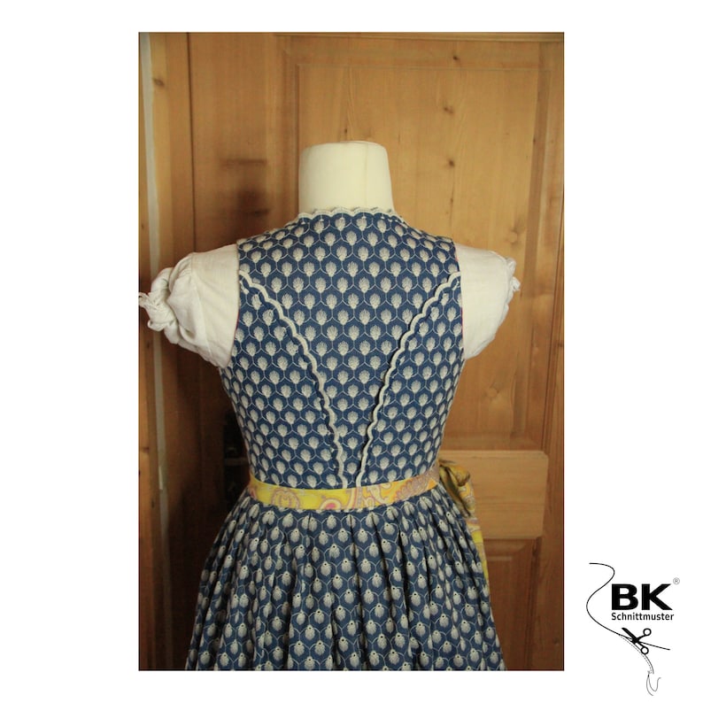 Peut inclure: Une robe traditionnelle bavaroise bleue et blanche avec une ceinture &agrave; motifs jaunes et roses. La robe est orn&eacute;e d'une dentelle blanche autour du col et d'une dentelle blanche autour du dos.