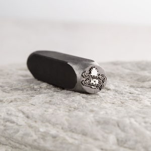 May include: A metal stamp with the words "Pineapple in Paradise" and a pineapple graphic.