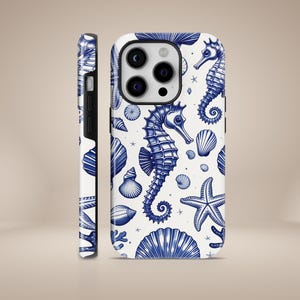 May include: A white phone case with a blue and white seahorse and seashell pattern. The case has a cutout for the camera lens.