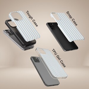 May include: Three phone cases are shown, each with a different design. The cases are labelled "Tough Case", "Snap Case", and "TPU Gel Case". Each case has a light blue and white striped pattern. The phones are black and silver.