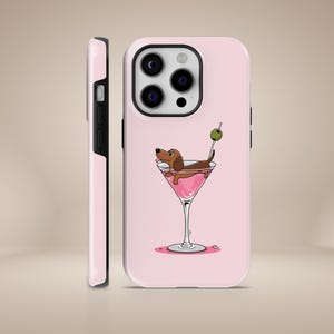 Könnte beinhalten: Rosa iPhone Hülle mit einem Dackel in einem rosa Martini-Glas. Der Hund hat braunes Fell und trägt eine grüne Olive an einem Stiel.