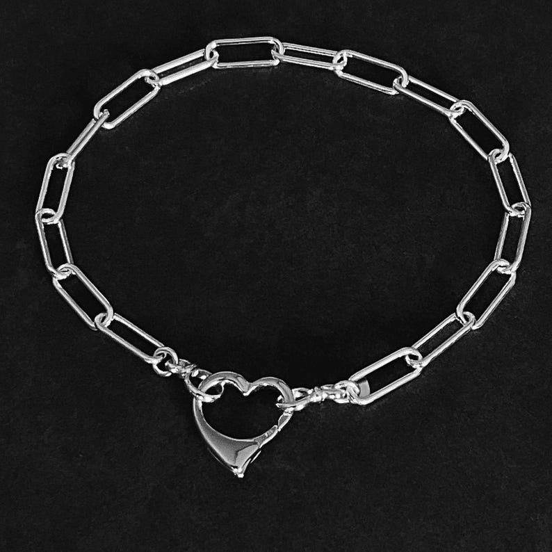 May include: A silver chain bracelet with a heart-shaped clasp.