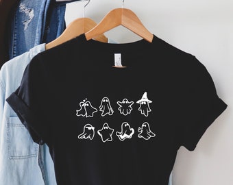 May include: Black t-shirt with a white graphic of nine ghosts in different poses, including one wearing a witch hat.