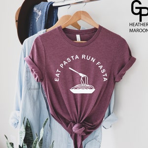 May include: A heather maroon t-shirt with a white graphic that says "Eat Pasta Run Fasta" with a fork and spaghetti illustration.