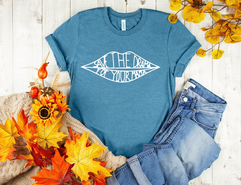 May include: A teal blue t-shirt with a white graphic of a pair of lips with the text "Save the drama for your mama" inside.