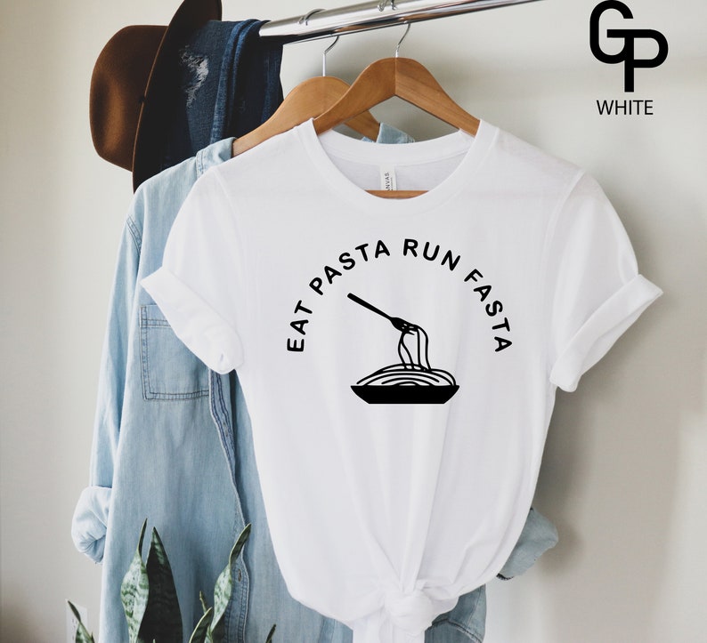 Może przedstawiać: Biała koszulka z czarnym napisem "Eat Pasta Run Fasta" i grafiką widelca i spaghetti w misce.