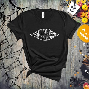 May include: Black t-shirt with a white graphic of a stylized mouth with the text "Save the drama for your mama" inside.