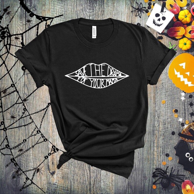 May include: Black t-shirt with a white graphic of a stylized mouth with the text "Save the drama for your mama" inside.