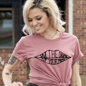 May include: A pink t-shirt with a black graphic of a pair of lips that says "Save the drama for your mama".