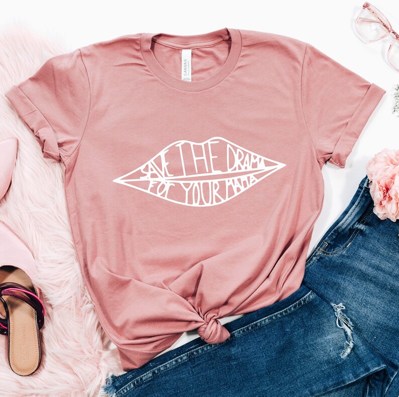 May include: A pink t-shirt with a white graphic of a pair of lips with the text "Save the drama for your mama" inside.