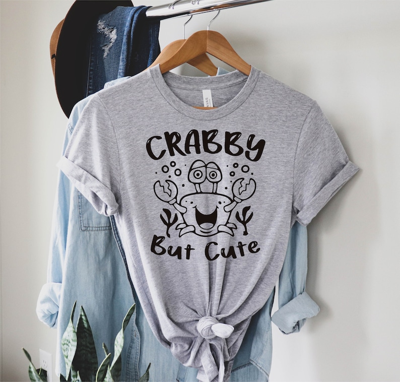 May include: Gray t-shirt with a black cartoon crab and the text "Crabby But Cute".