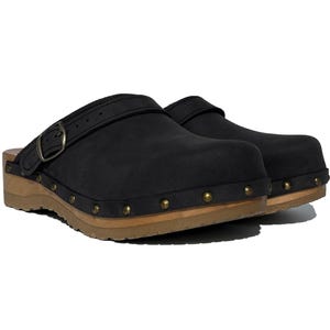 May include: Black leather clogs with a buckle strap and wooden platform sole. The clogs have metal studs around the sole.