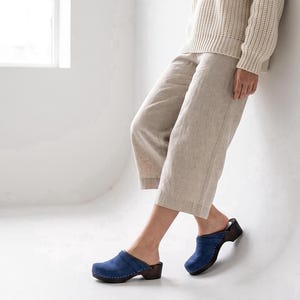Zuecos suecos de piel azul oscuro con suela ortopédica de madera de aliso.