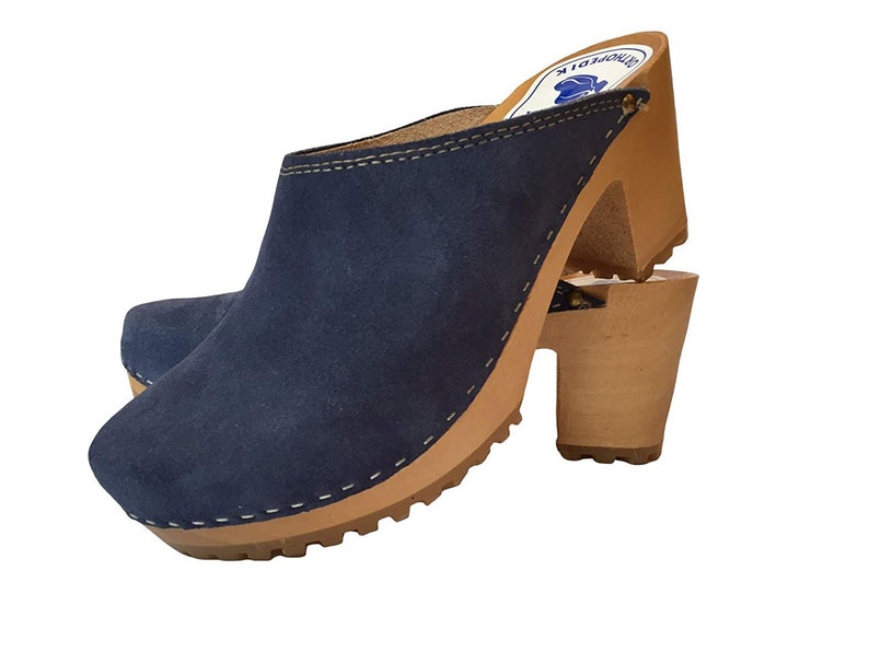 May include: Blue suede clogs with a wooden heel and a stitched seam around the top edge. The clogs have a brown wooden sole with a textured tread.
