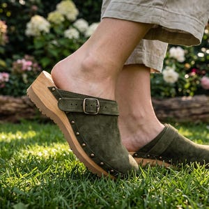 Zuecos de cuero verde con suela de madera y tachuelas antiguas.