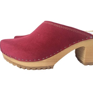 May include: Red suede clogs with a wooden heel and a thick, textured sole.