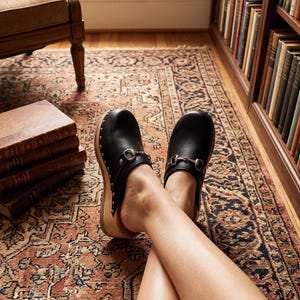 Schwarze Lederclogs mit Holzsohle und Metalldetails