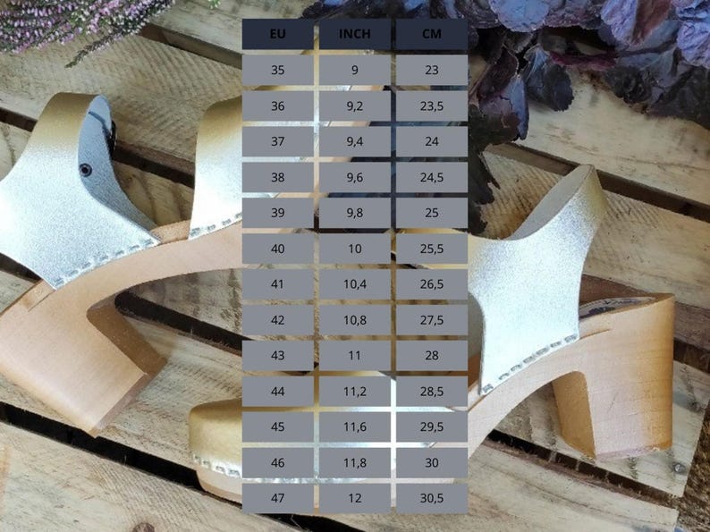 A size chart for clogs is displayed over a background of wooden planks and purple flowers, with columns for EU, Inch, and CM sizes.