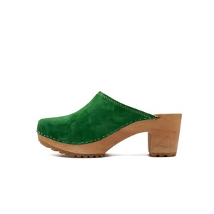 Puede incluir: Zuecos de tac&oacute;n de ante verde con plataforma y tac&oacute;n de madera.