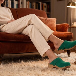 Sabots suédois en cuir vert, semelle en bois confortable.
