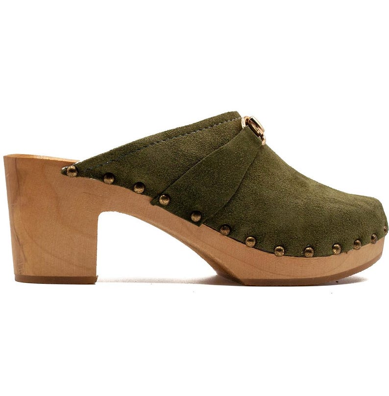 May include: Green suede clogs with a wooden heel and a gold buckle. The clogs have a studded design.