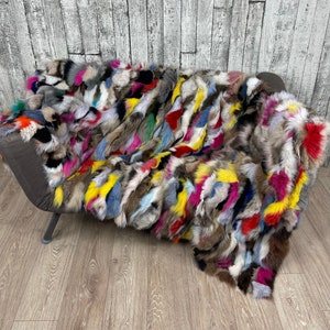 Könnte beinhalten: Eine bunte Patchwork-Felldecke mit einer Vielzahl von Farben und Texturen. Die Decke ist aus verschiedenen Fellarten gefertigt, darunter Fuchs, Kaninchen und Nerz. Sie ist eine luxuriöse und stilvolle Ergänzung für jedes Zuhause.