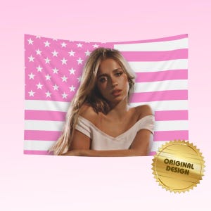 May include: A rectangular wall tapestry featuring a pink and white American flag pattern with a central photographic portrait of a person with long blonde hair wearing a white off-the-shoulder top. A gold circular seal reads ORIGINAL DESIGN.